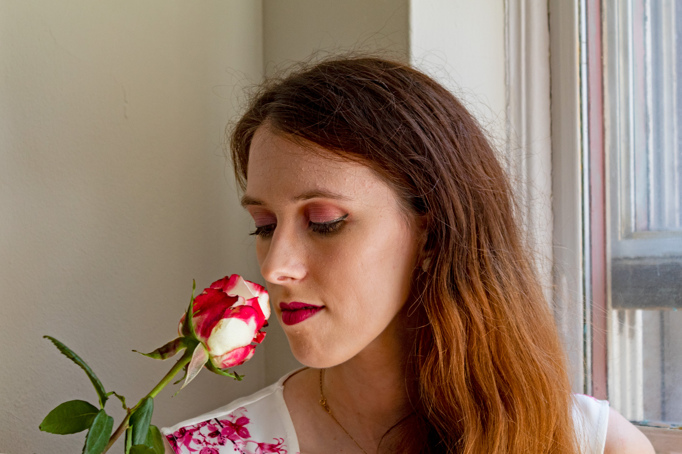 Woman smelling a red and white rose